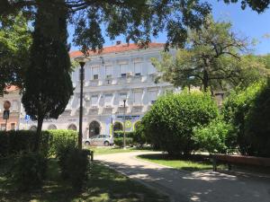 Un gran edificio blanco con una farola delante. en 1890's Apartment, en Mostar