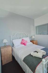 a bedroom with a large bed with a pink pillow at Montague House Apartments in Llandudno