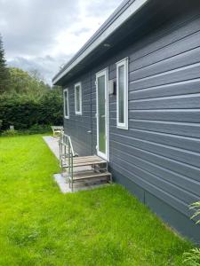 una casa azul con un banco al lado de un patio en Mooi verblijf op rustig park, en Ermelo