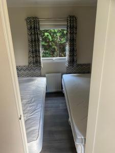 a small room with two beds and a window at Mooi verblijf op rustig park in Ermelo