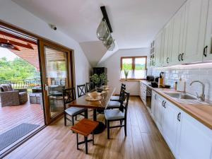 a kitchen and dining room with a table and chairs at Domek pod Katalpami in Głowno