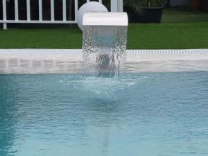 una fuente en medio de una piscina de agua en Casa Nine con piscina en Breña Baja