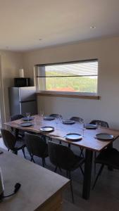 a large wooden table with chairs and wine glasses at Appartement Le Grand Duc in Gérardmer