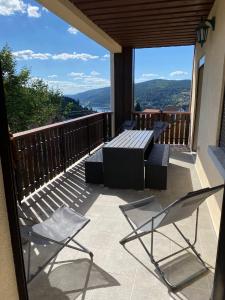 een patio met een tafel en stoelen op een balkon bij Appartement Le Grand Duc in Gérardmer