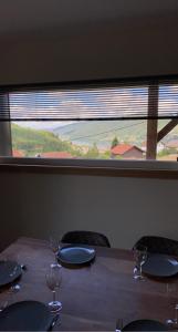 a table with wine glasses and a large window at Appartement Le Grand Duc in Gérardmer