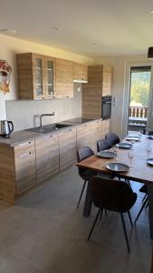 a kitchen with a table and chairs and a sink at Appartement Le Grand Duc in Gérardmer