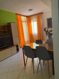 a dining room with a table and chairs and a television at Apartmani Petra i Igor in Makarska