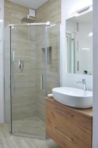 La salle de bains est pourvue d'un lavabo et d'une douche en verre. dans l'établissement Znowu wrócisz, à Białogóra