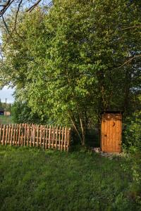 a wooden shed in a field next to a fence at Stan u.nás in Dolní Řasnice