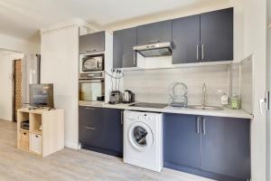a kitchen with blue cabinets and a washing machine at Appartement Gare St Charles Vieux Port in Marseille