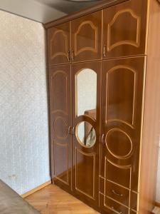 a wooden cabinet with a mirror in a room at Apartment near Airport and station Charbakh in Yerevan