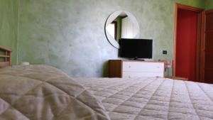 a bedroom with a bed and a tv and a mirror at Aurora B&B in Gussola