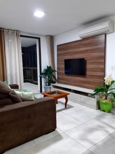 a living room with a couch and a flat screen tv at Apartamento Waiwai Cumbuco in Cumbuco