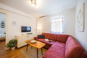 a living room with a red couch and a table at Apartments Odrina in Split