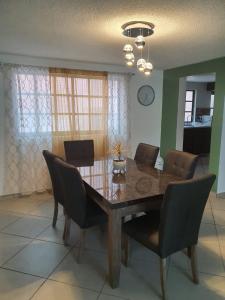 a dining room with a wooden table and chairs at Suites Incoreli in Pachuca de Soto