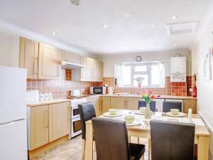 a kitchen with a table and chairs and a white refrigerator at 7 Dolydd Terrace in Tanygrisiau