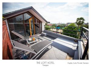 ein Haus mit einem Balkon mit vielen Fenstern in der Unterkunft The Loft Hotel Downtown Yangon in Yangon
