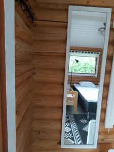 a mirror in a tiny house with a bedroom at Hirsimökki ja makuuaitta in Karijoki