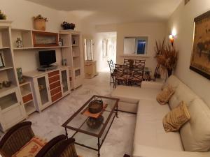Una sala de estar con un sofá blanco y una mesa. en Costa ballena, playa del infante, en Cádiz