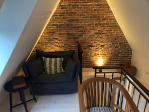 een trap met een blauwe bank en een bakstenen muur bij Knuffelkamer über der Gracht in Friedrichstadt