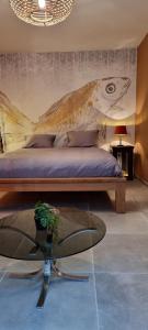 a bedroom with a bed with a painting on the wall at Logies La Chèvre Folle in Ostend