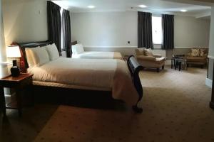 a hotel room with a large bed and a couch at The Tudor Hotel in Harrow