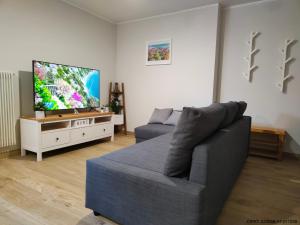a living room with a couch and a flat screen tv at Pordoi H10 - with SAUNA in Alba di Canazei