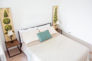 a bedroom with a white bed with a blue pillow at [Lake Maggiore Apt] ✦ Relax accanto alla spiaggia in Lisanza