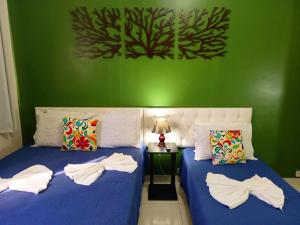 - 2 lits dans une chambre dotée d'un mur vert dans l'établissement Home Office na Praia de Copacabana TC1204, à Rio de Janeiro