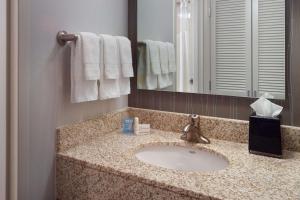 a bathroom with a sink, mirror, and towel rack at Sonesta Select Atlanta Airport North in Atlanta