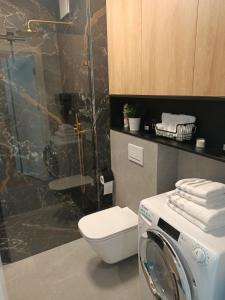 a bathroom with a washing machine and a toilet at Apartament Maris Gdynia - Śródmieście - Klimatyzacja - Prywatny Parking in Gdynia