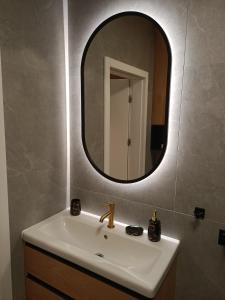 W łazience znajduje się umywalka i lustro. w obiekcie Apartament Maris Gdynia - Śródmieście - Klimatyzacja - Prywatny Parking w mieście Gdynia