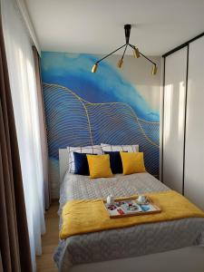 a bedroom with a bed with a painting on the wall at Apartament Maris Gdynia - Śródmieście - Klimatyzacja - Prywatny Parking in Gdynia