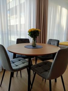 stół z krzesłami i wazon kwiatów na nim w obiekcie Apartament Maris Gdynia - Śródmieście - Klimatyzacja - Prywatny Parking w mieście Gdynia