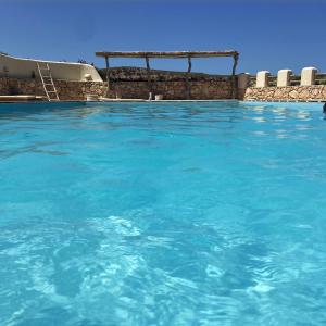 une grande piscine d'eau bleue avec dans l'établissement Sweet Dome Tafedna, à Borj