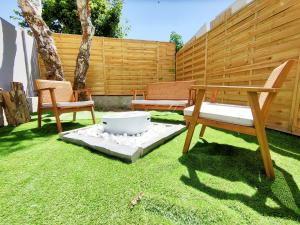 un cortile con due sedie, una panchina e una recinzione di SPA 100m plage BRASERO design KITESURF a Berck-sur-Mer