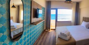 Cette chambre d'hôtel comprend un lit et offre une vue sur l'océan. dans l'établissement The Kirte Hotel V Beach, 
