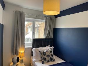- une chambre avec un mur rayé bleu et blanc dans l'établissement Stylish 3 bed house, private parking, garden and conservatory, à Sheffield