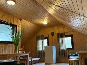 Habitación con techo de madera y nevera. en Strautmali, en Mazirbe