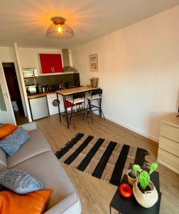 salon z kanapą i stołem w obiekcie Cosy Appartement vue mer w mieście Camiers