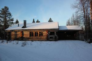 ein Blockhaus mit einem schneebedeckten Dach in der Unterkunft Rukanhelmi Cottage in Ruka