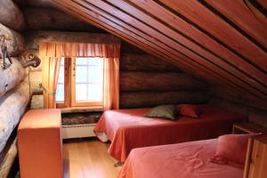 a bedroom with two beds in a log cabin at Rukanhelmi Cottage in Ruka