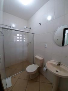 a bathroom with a shower and a toilet and a sink at Hotel Nossa Senhora do Carmo in Ilha Comprida