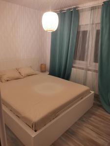 a bedroom with a bed with blue curtains and a chandelier at Bloom Box Apartments in Craiova