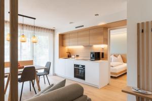 a kitchen and living room with a table and a bed at VANEA - Alp Relax Guesthouse in Chienes