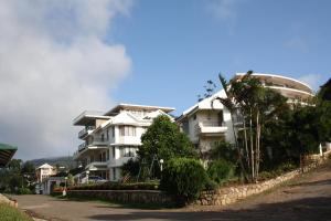 钦纳卡纳Ayur County Resort的一座白色的大建筑,烟从里面冒出来