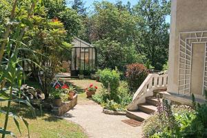 een tuin met potplanten en een kas bij Gîte atypique vue panoramique in Montrevault