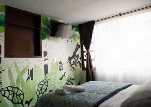 1 dormitorio con 1 cama y TV en la pared en Casa Mood Usaquen, en Bogotá