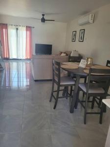 a living room with a table and chairs and a television at Tranquil 2 bedroom townhouse in Discovery Bay in Discovery Bay