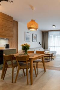 シュチルクにあるWILANESKA Apartament Olimpijska Szczyrkのダイニングルーム(木製テーブル、椅子付)